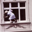 Lady dangerously hangs out of window when cleaning